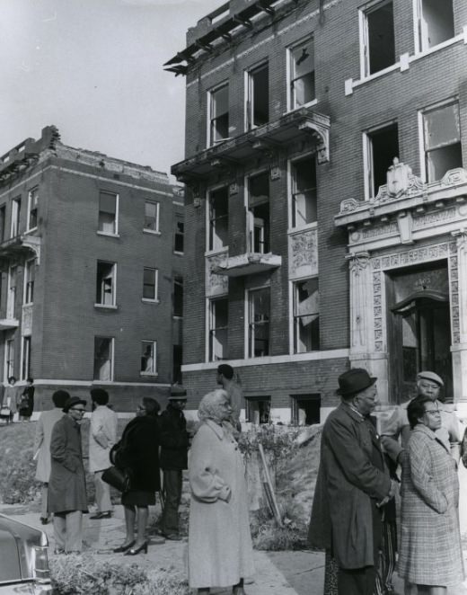 Community members stand in front of a neighborhood of abandoned buildings on the 4500 block of Washington, 1971
