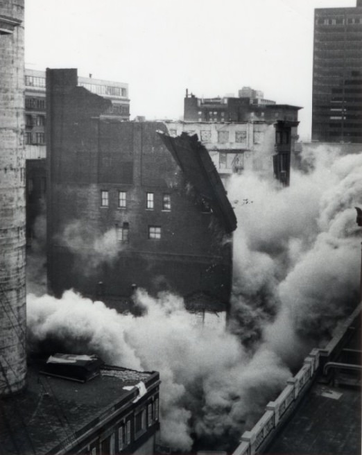 Smoke surfaces as the building begins to dismantle, 1972