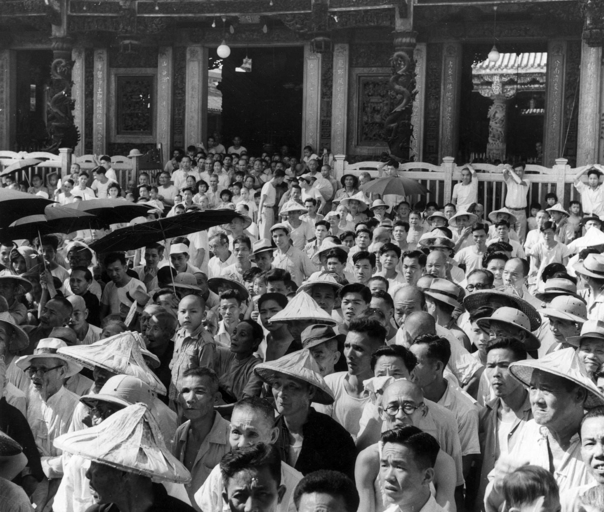 A crowd watching a performance of Chinese opera by a traveling theater company at Taipei, Taiwan, 1955