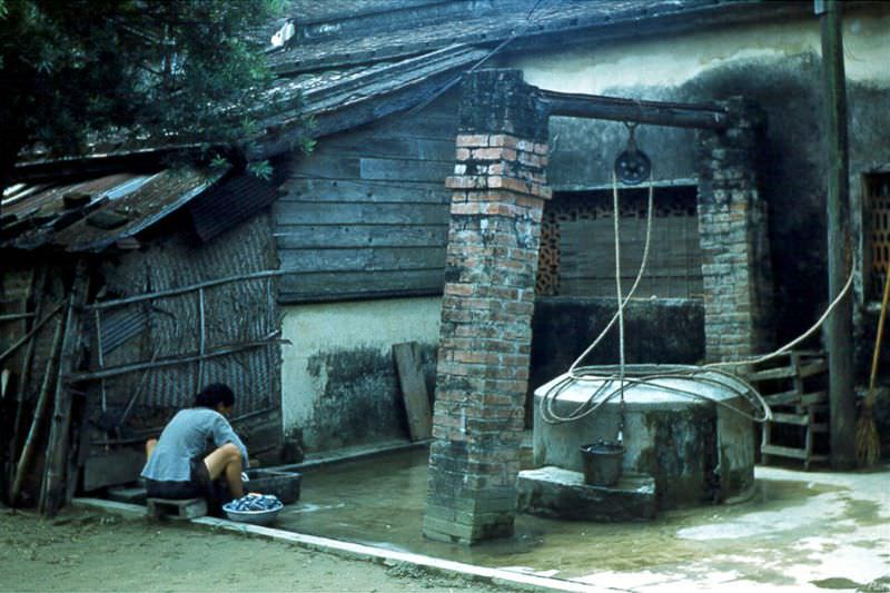A monk doing laundry beside a well inside the monastery, Tainan, Taiwan, 1954