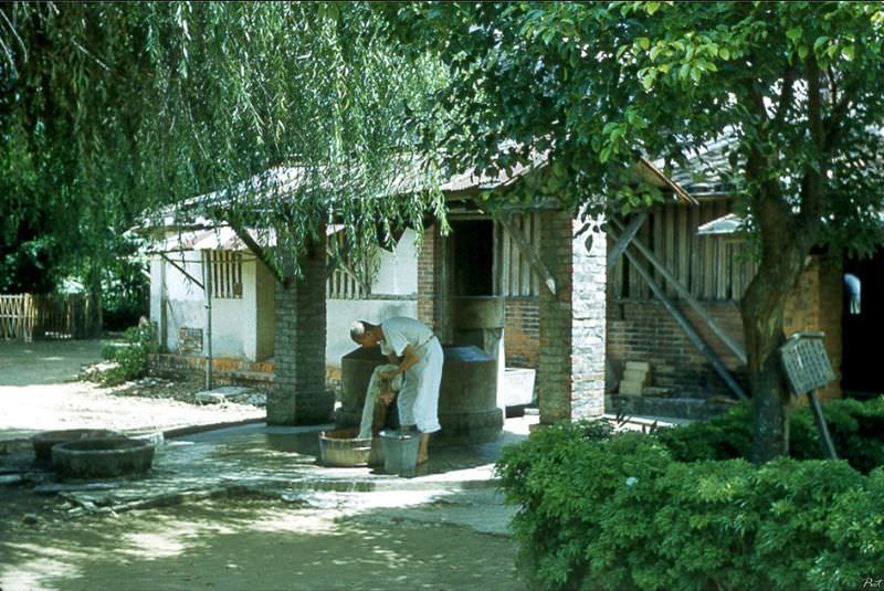 A monk doing laundry beside a well inside the monastery, Tainan, Taiwan, 1954