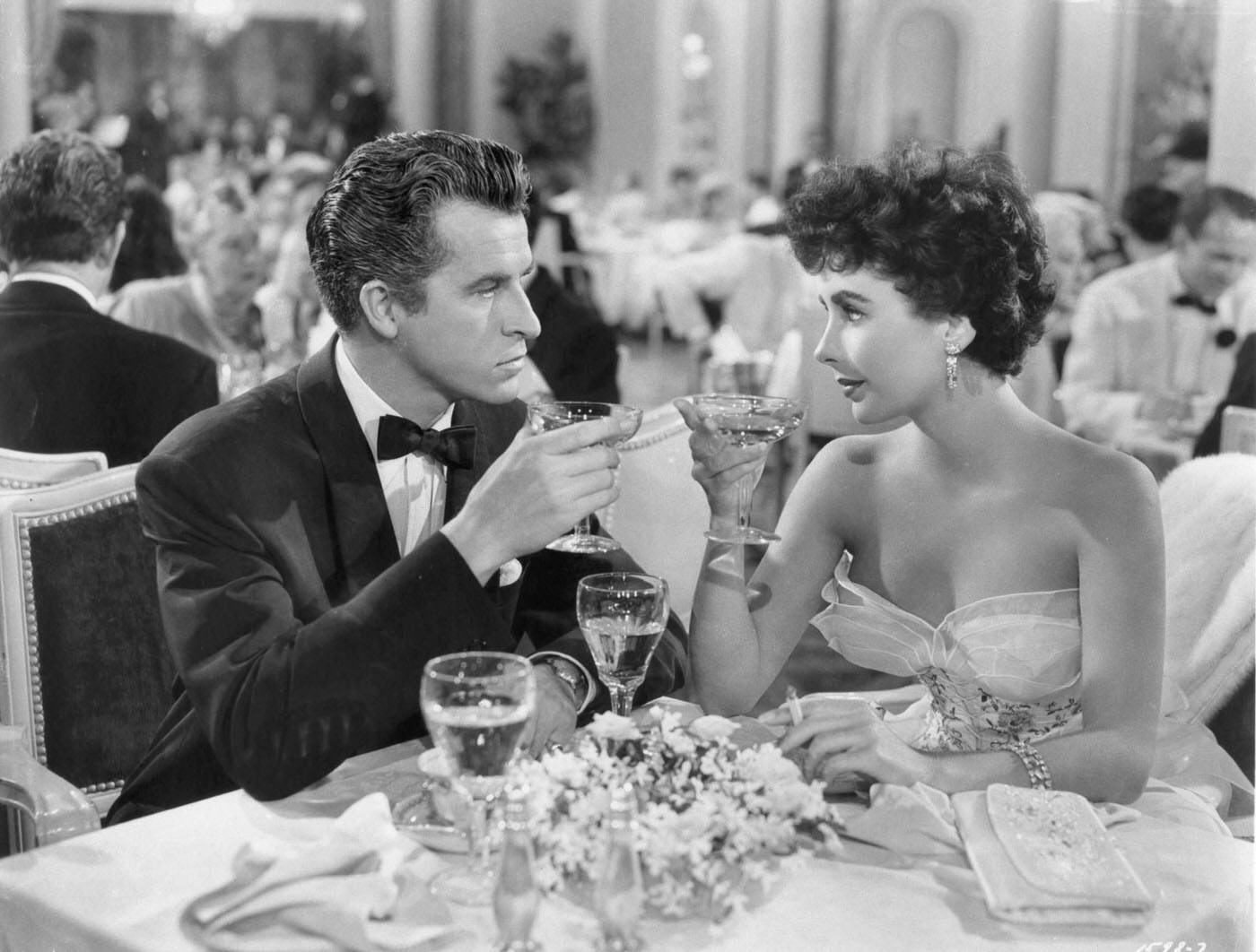 Fernando Lamas and Elizabeth Taylor share a drink in a scene from 'Girl Who Had Everything' (1953).