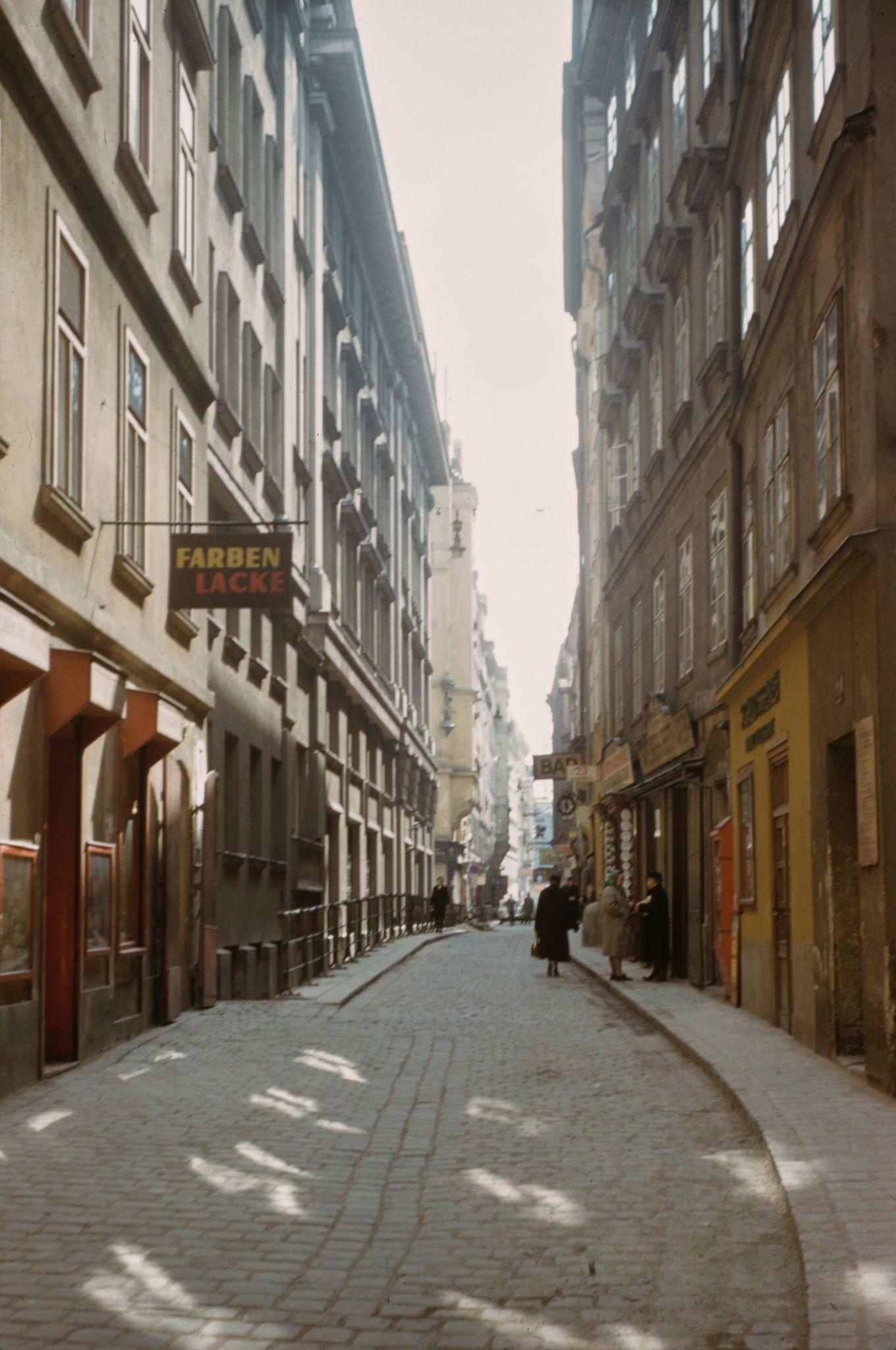 Pedestrians walking down a narrow street in the centre of Vienna in 1950.