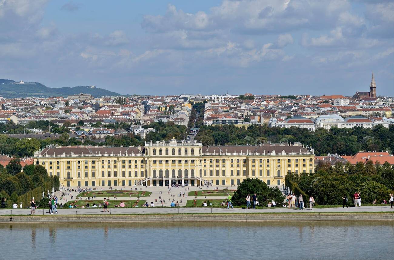 Aerial view of Schönbrunn Palace in Vienna, Austria, with the garden in the front and the city in the background.