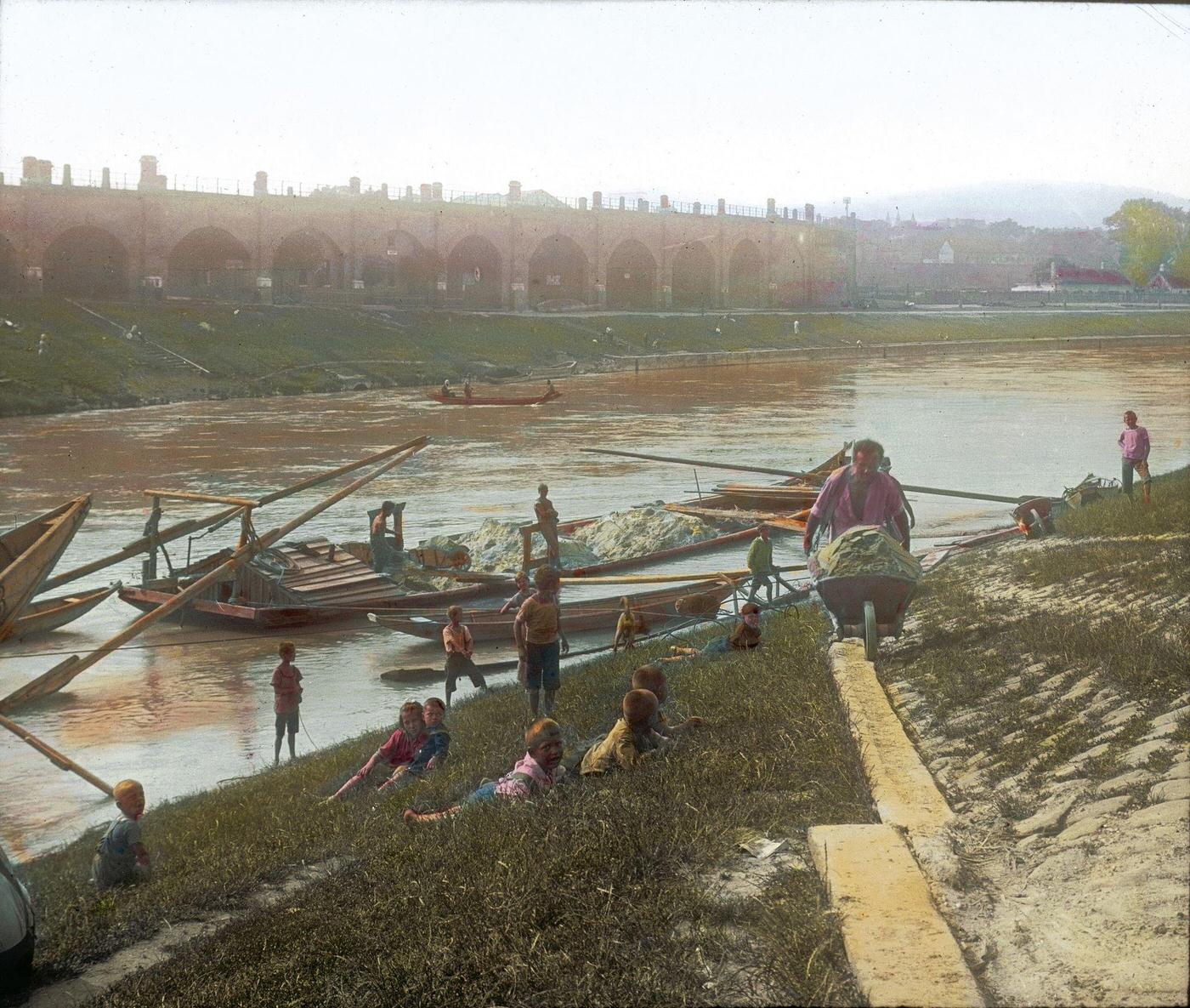 Unloading sand from a barge at the Brigittenauer Laende, with a view of the Viennese Stadtbahn on the opposite bank, 1905.