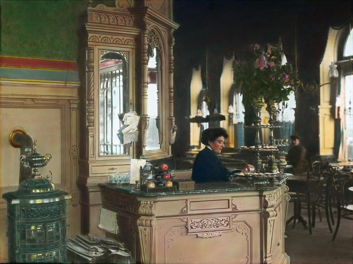 Female employee at the checkout in a Viennese coffeehouse. Vienna, 1905.