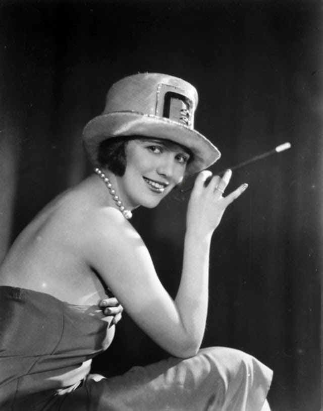 British character actress Enid Stamp-Taylor (1904–1946) smoking with a long cigarette holder, 1926.