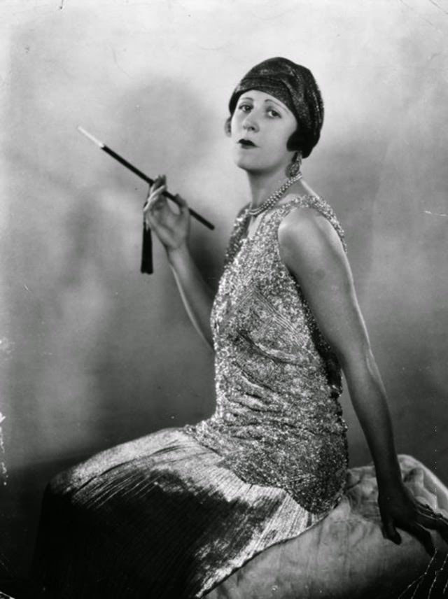 Actress Betty Langford smoking with a cigarette holder, 1927.