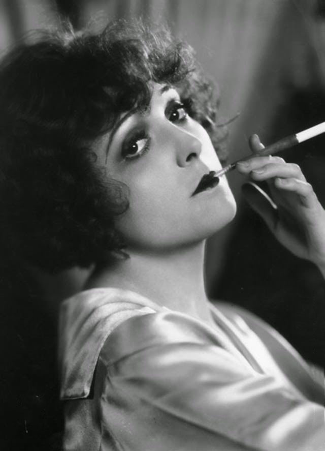 Madge Bellamy, the stage name of Margaret Philpott (1899–1990) the American general purpose actress of the 20s. She was a former dancer and beauty queen. Pictured in languid pose, smoking a cigarette, using a long cigarette holder, 1920