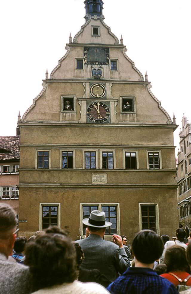 People watching the mechanical clock strike the hour, Market Square, Rothenburg.