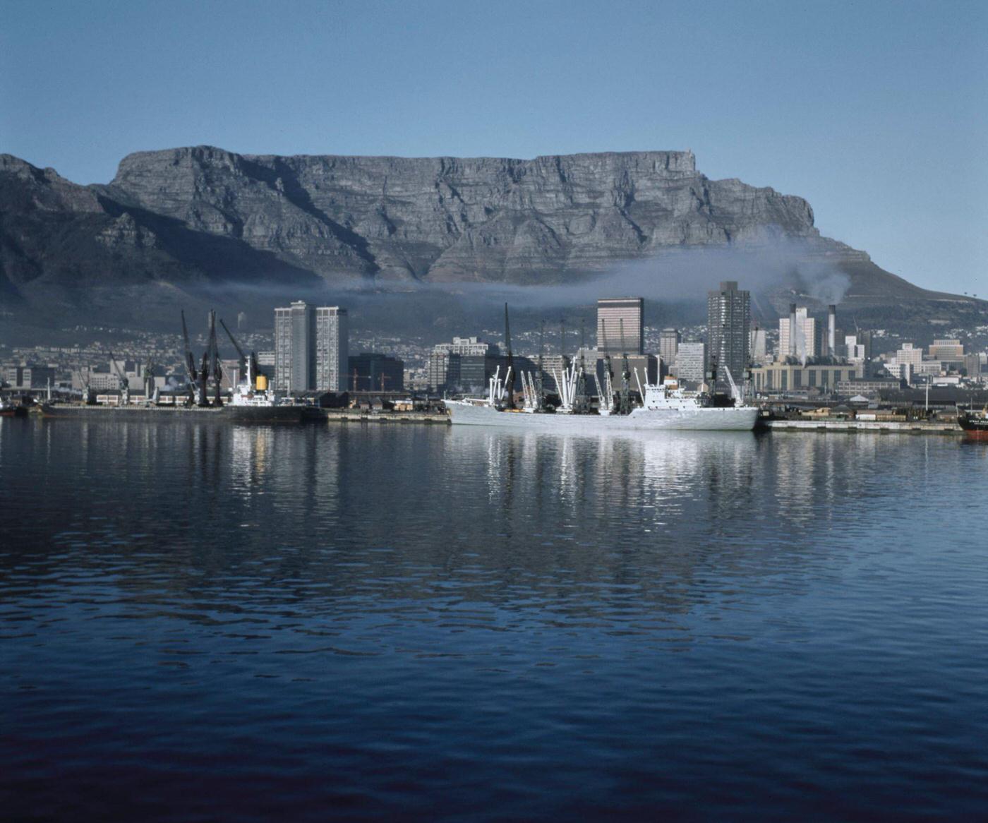 Cargo ships moored in the harbor of the Port of Cape Town below Table Mountain in the city of Cape Town, 1965