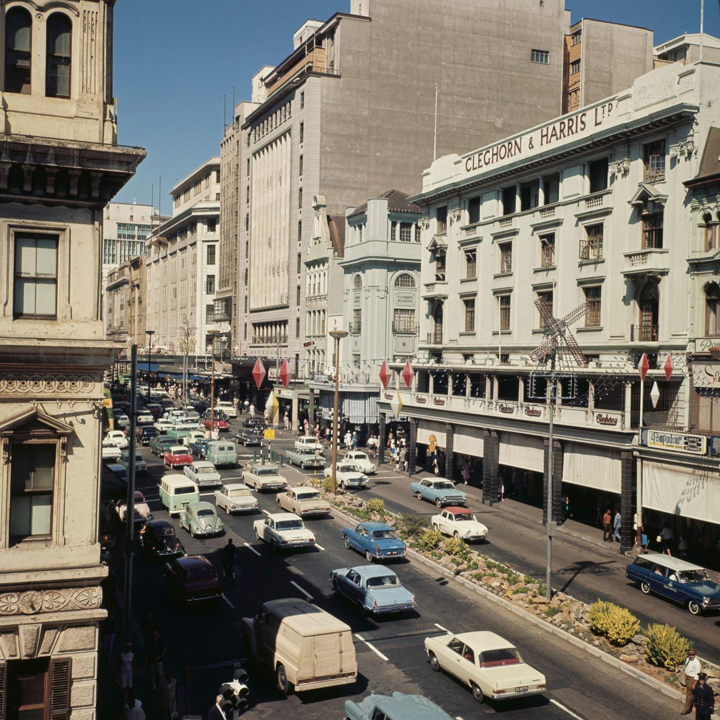 Pedestrians and traffic pass the Cleghorn & Harris department store on Adderley Street in the centre of the city of Cape Town, 1966