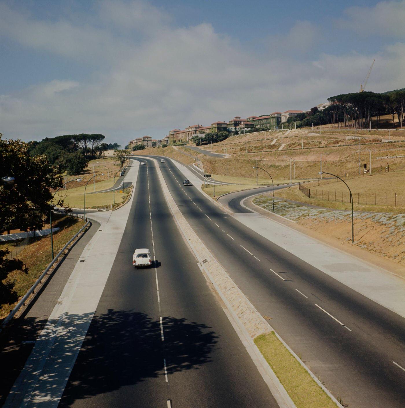 Cars drive along Rhodes Drive towards the Upper Campus of the University of Cape Town on the slopes of Devil's Peak in the city of Cape Town in Cape Province (later Western Cape) in South Africa in 1966.