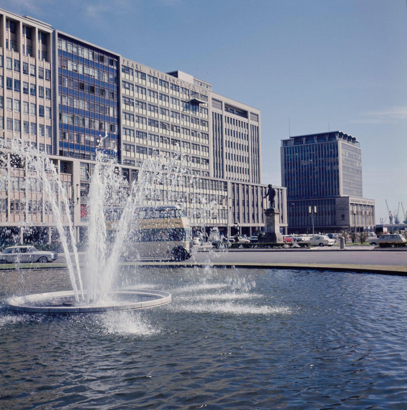 Traffic drives past the Adderley Street Fountain in the Foreshore Place district of the city of Cape Town, 1966