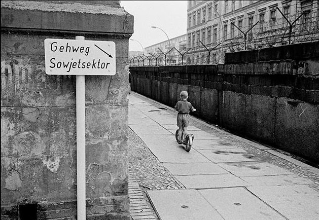 Child with scooter at the Berlin Wall. This pedestrian way belongs to the Soviet Sector of Berlin.