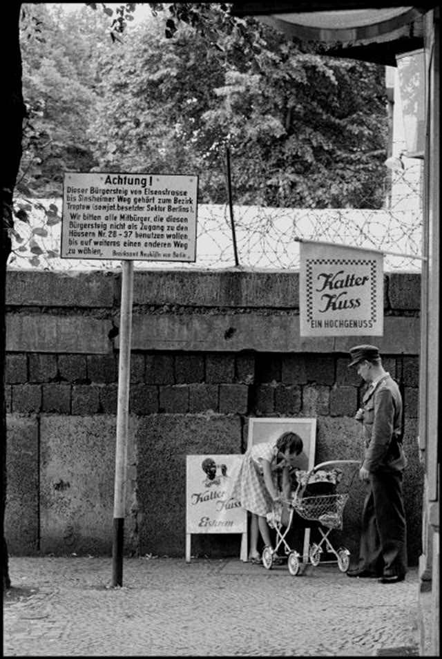 Girl and West Berlin Policeman in front of the Berlin Wall in Berlin Wedding.