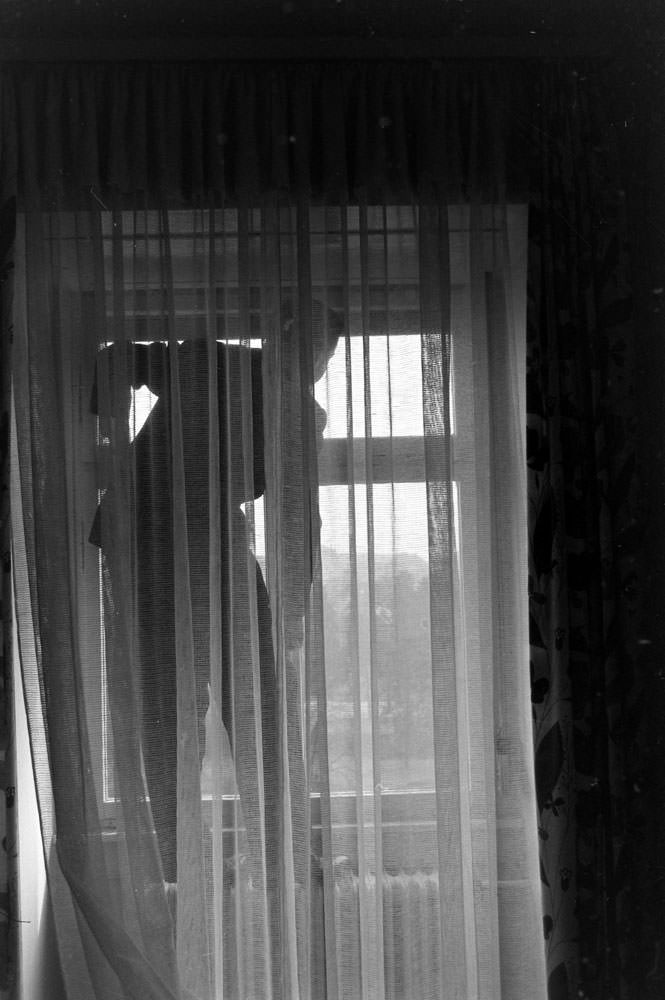 Sgt. Elvis Presley peers out of the window of the house he and his family occupied in Bad Nauheim, Germany, March 1960.