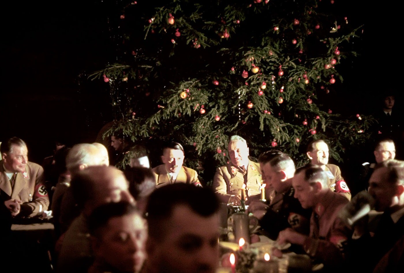 Adolf Hitler (center) sits with Heinrich Himmler to his left, who was the commanding officer of the Nazi secret police.