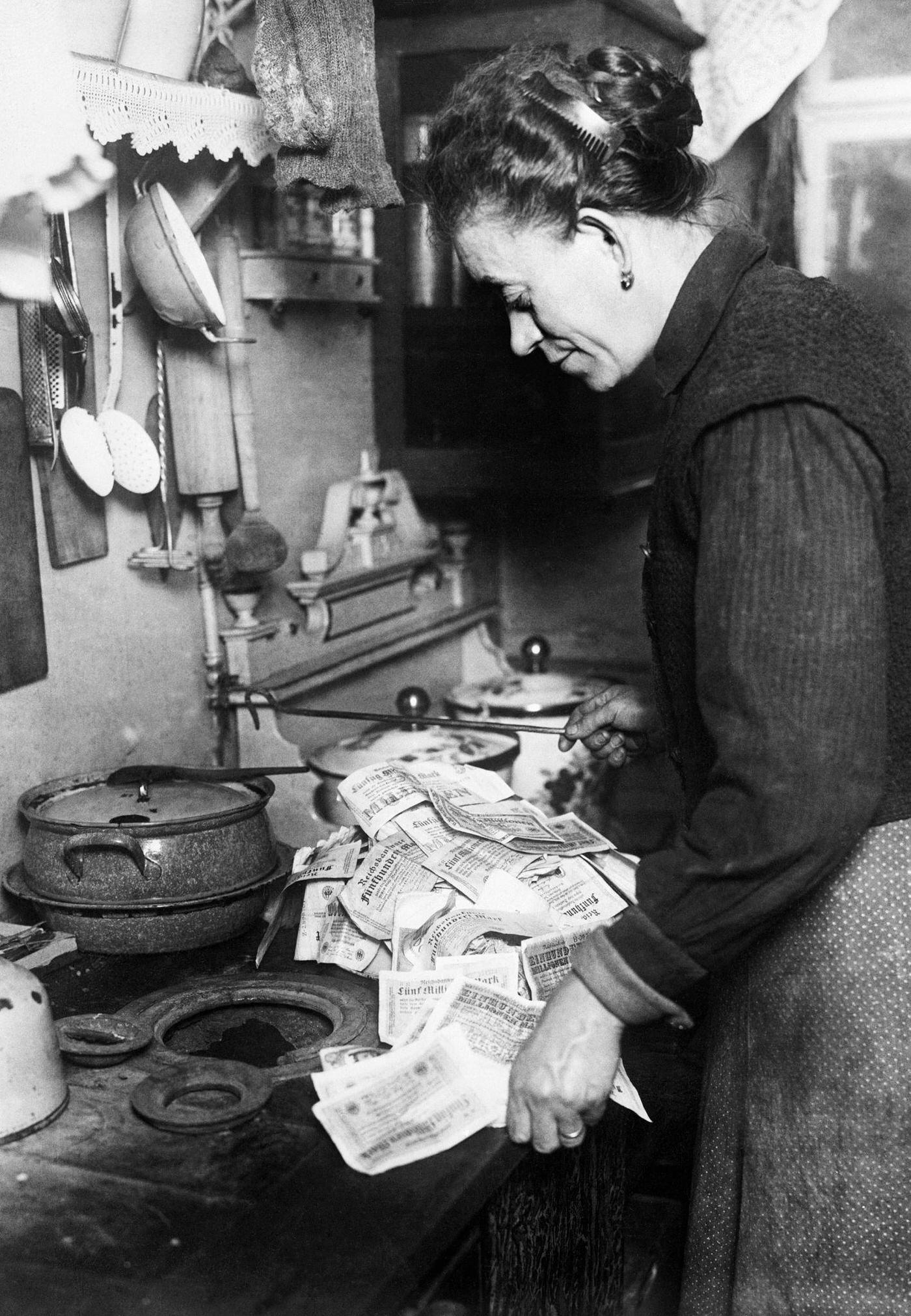 Woman uses money to light stove, Germany's hyperinflation.