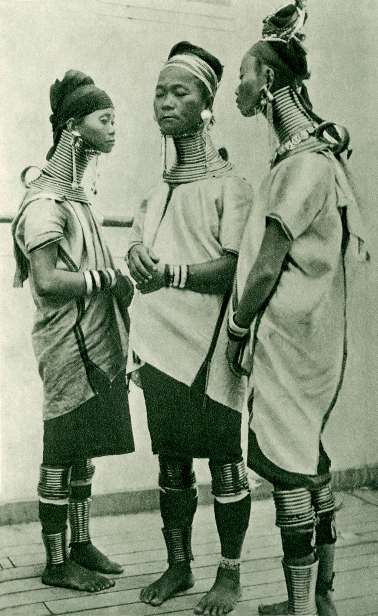 Three Padaung giraffe women wearing brass rings around their necks, Padaung, Burma.