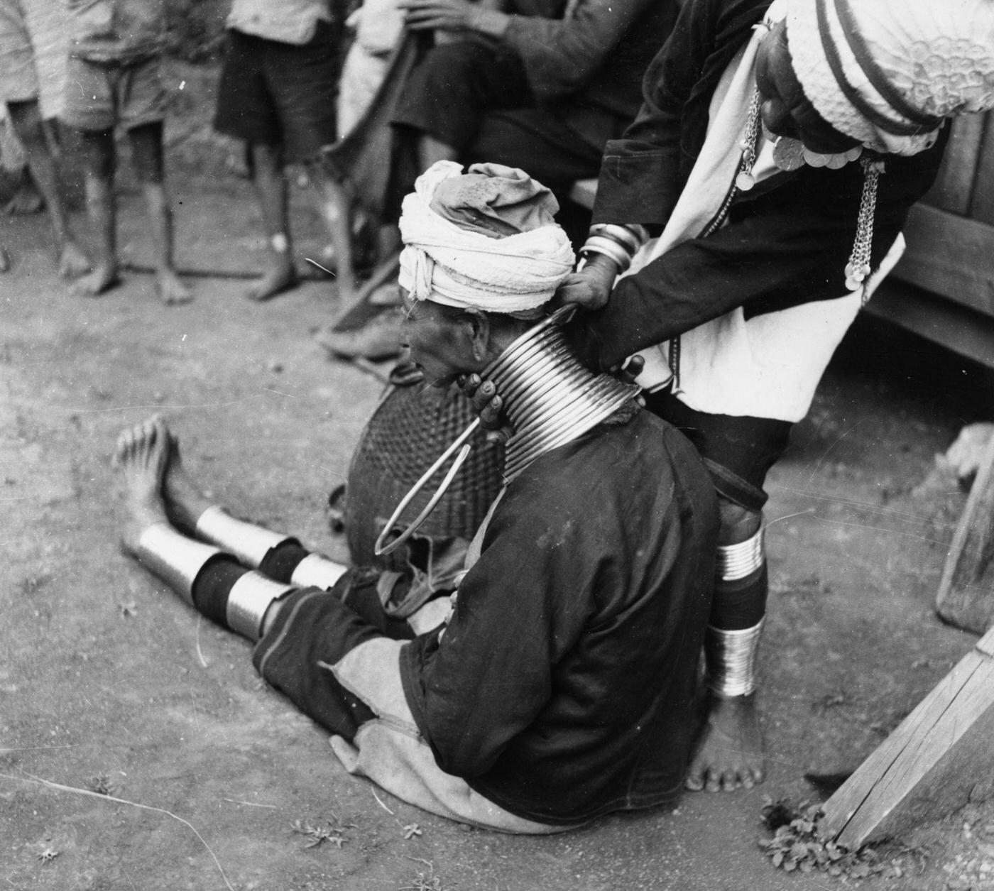 A Padaung woman getting a new brass ring fitted around her neck, Burma, 1950.