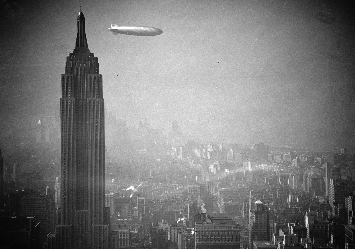The Zeppelin Hindenburg floats past the Empire State Building over Manhattan, Aug. 8, 1936