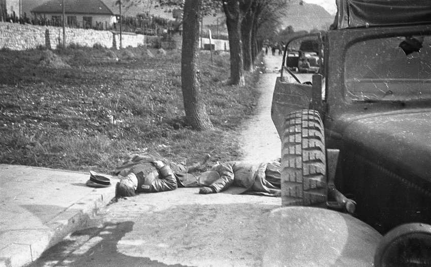 Somewhat later, the photographer apparently left his position in the camp to get a closer look at the two dead German officers. The bodies by this point had been moved from the center to the side of the street.