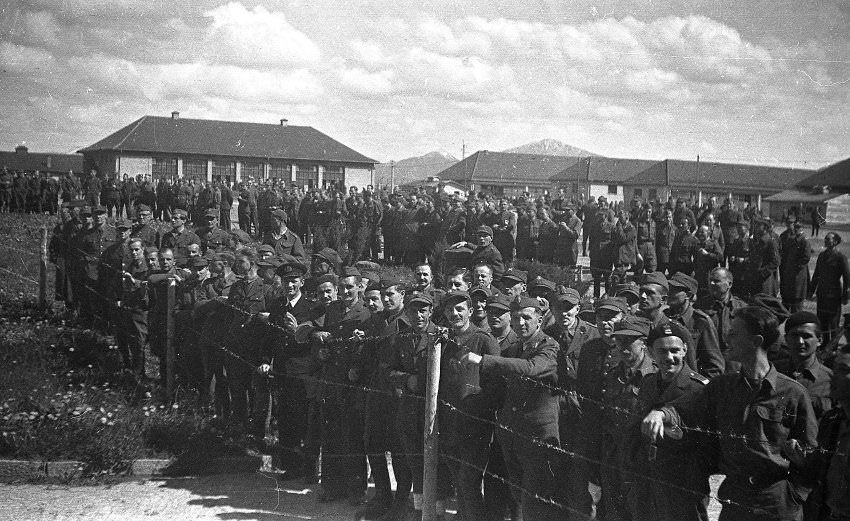 This photo was taken after the camp's liberation. The men are apparently waiting for the truck that would take them away.