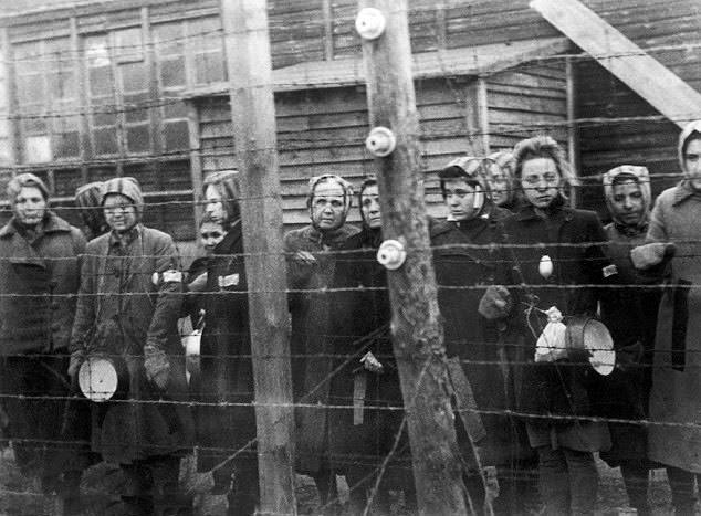 Prisoners at Ravensbrück concentration camp in Germany stand near barbed wire in 1945