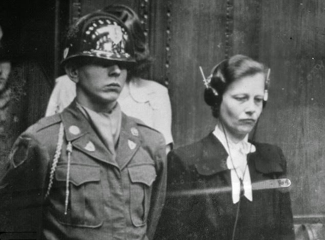 Dr Herta Oberheuser, a physician who worked at Ravenbruck concentration camp, is flanked by a US guard while on trial for war crimes including injecting prisoners with petrol and deliberately inflicting wounds for experiments