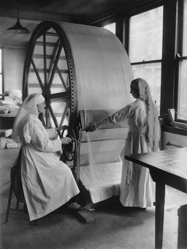 Women operate the new stretching machine for surgical dressing at the Red Cross headquarters in Cincinnati, Ohio, circa 1915.