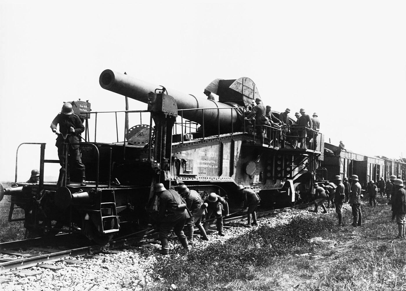 German troops setting the azimuth for horizontal lay on a 28 cm rapid-firing gun mounted on a train.