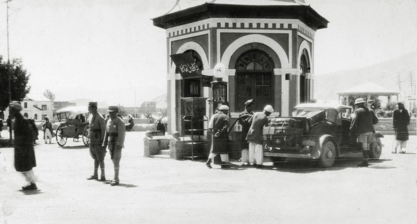 People at a petrol filling station on a Kabul street, circa 1950.