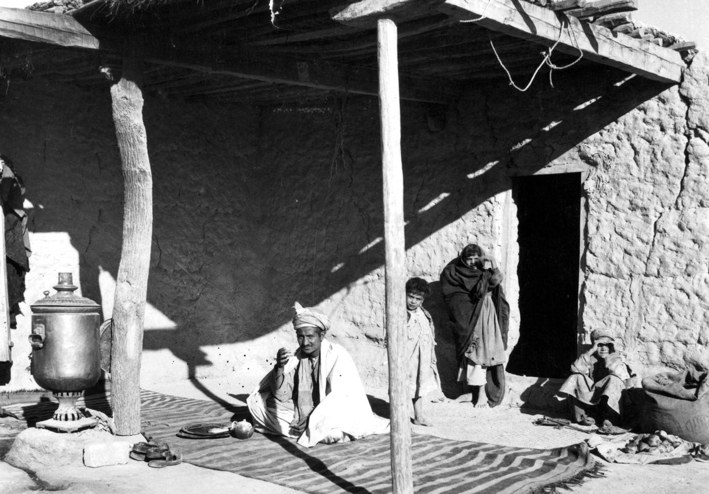 Man sitting outside with a Somovar for making tea, Afghanistan, 1955.