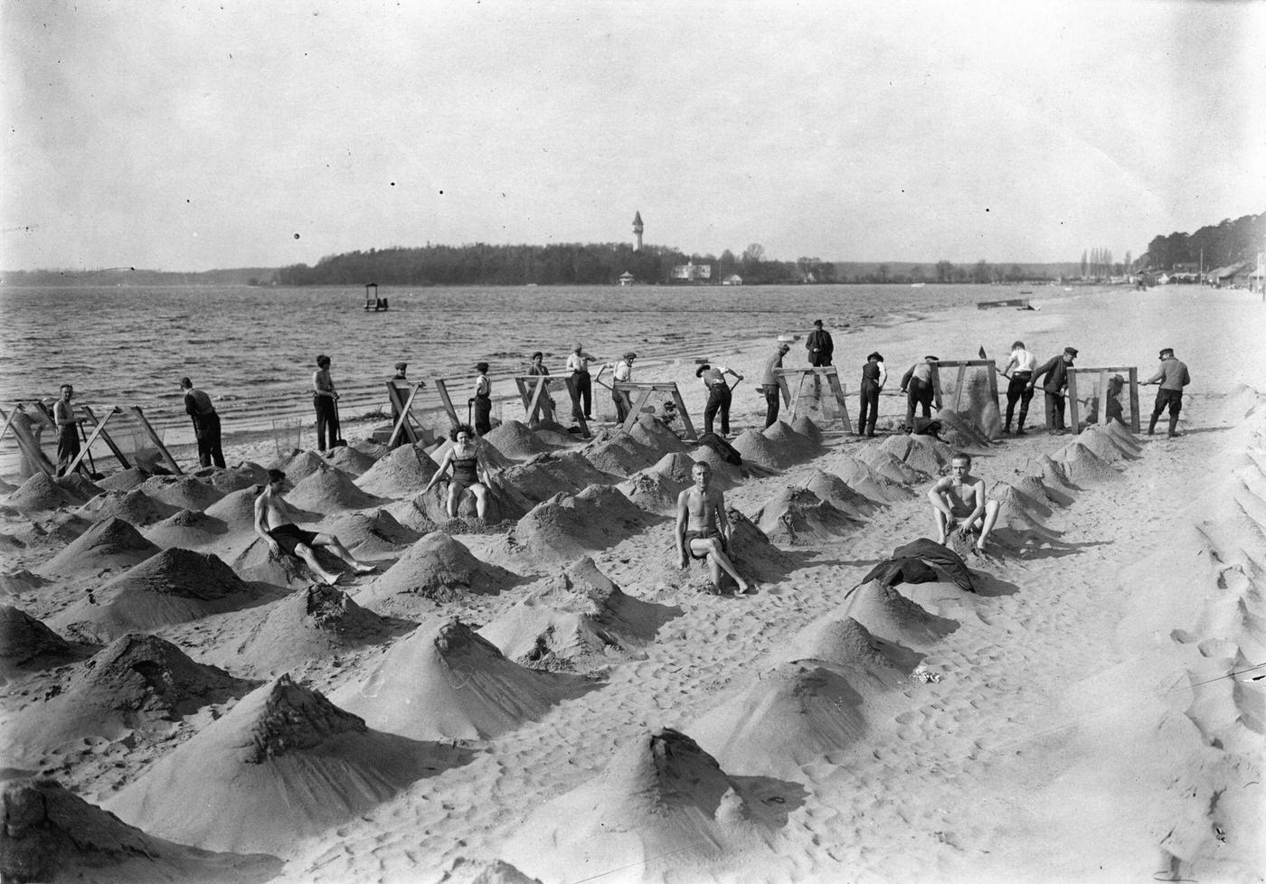 Yearly before the opening of the Wannsee beach several people searching for valuable objects, Berlin, Germany, 1930