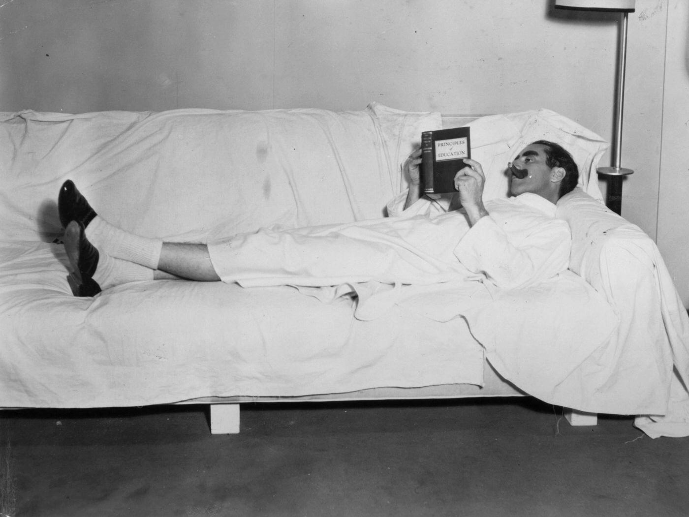 Groucho Marx takes a break while filming Duck Soup (1933), reading "Principals of Education."