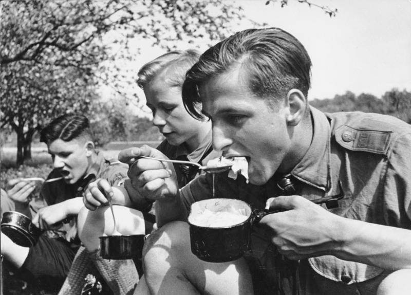 Hitler Youth members eating a meal while on a field exercise