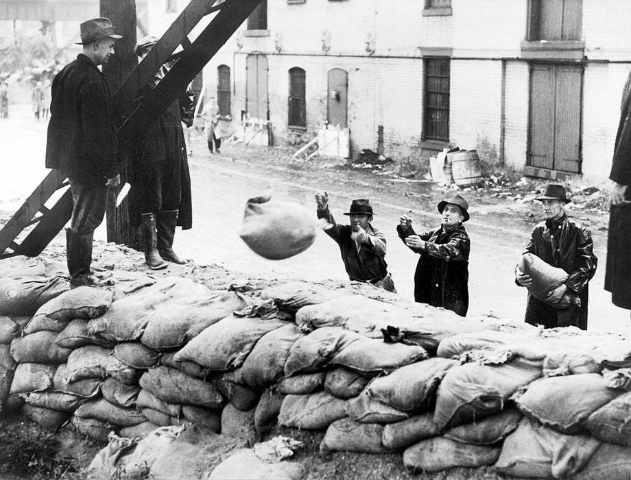 A small group of men, part of a larger army of workers and 70 trucks, reinforced dykes with sandbags to protect the 5-mile area controlled by Richmond’s Shockoe Creek Pumping Station from flooding caused by a severe storm, 1935.