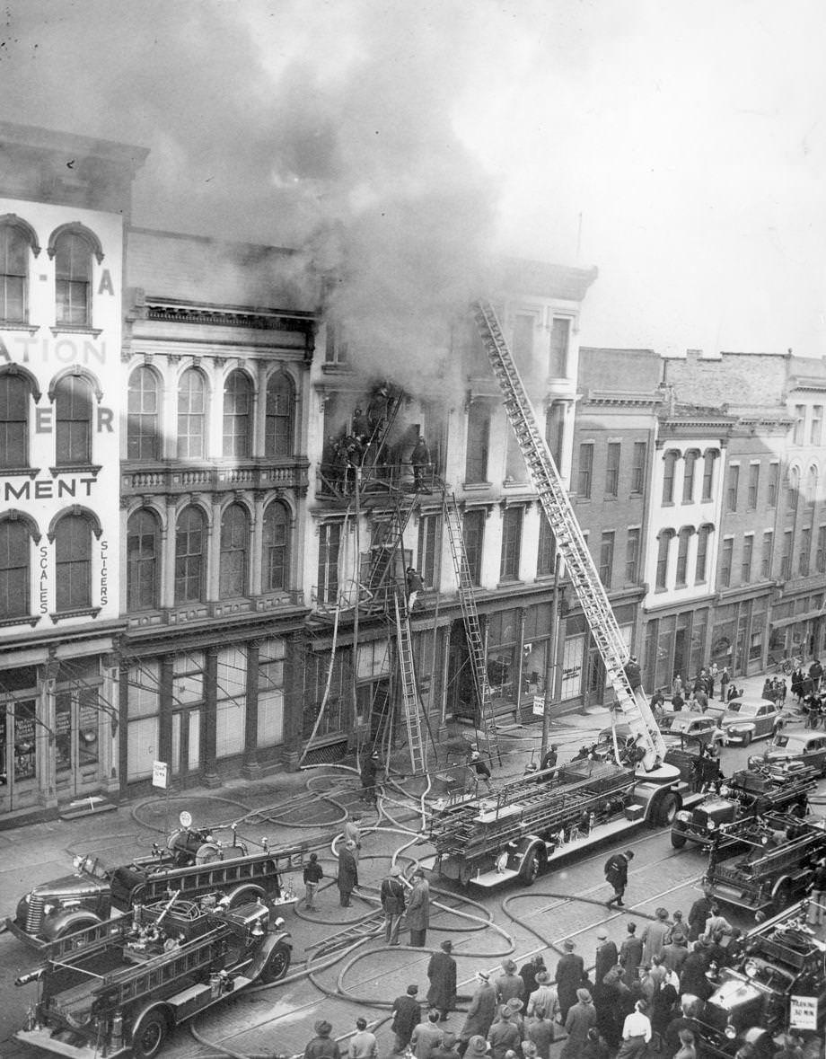 Rush hour crowd watches smoke pour from building at 14th and Main during fire, 1948.