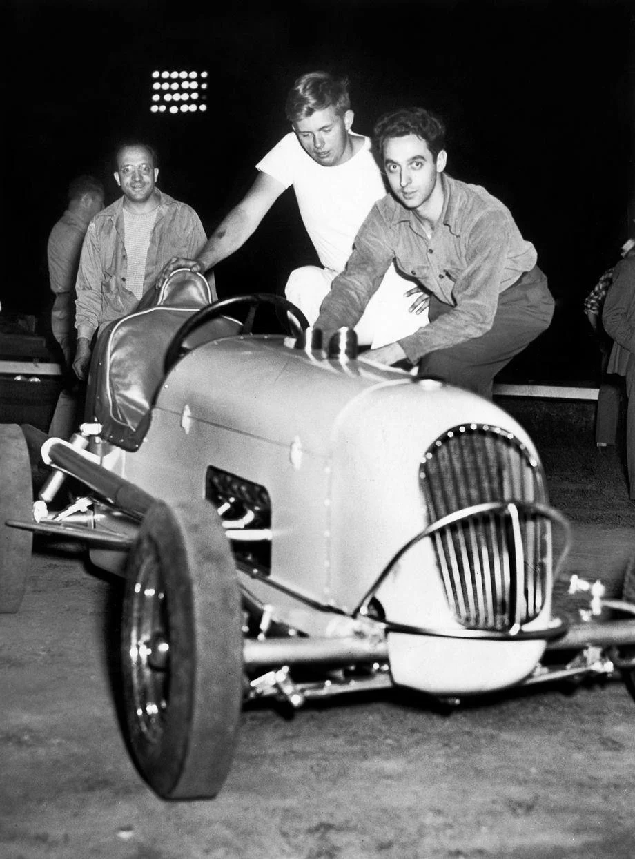Richmond midget car driver Cary Williams (in white T-shirt) and mechanic Charles Nigro pushed out the new Ford-Kurtiscraft car, which Nigro built, in preparation for racing at Richmond Stadium Speedway, 1947.