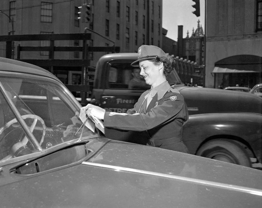 New policewoman Martha S. Jackson placed one of her first tickets on an illegally parked car, 1952.