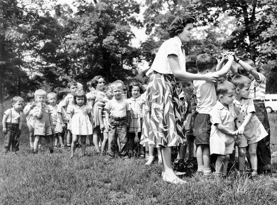 June Maile showed youngsters from the Belle Bryan Day Nursery how to play “London Bridge is Falling Down” during the nursery’s annual outing at Byrd Park, 1951.