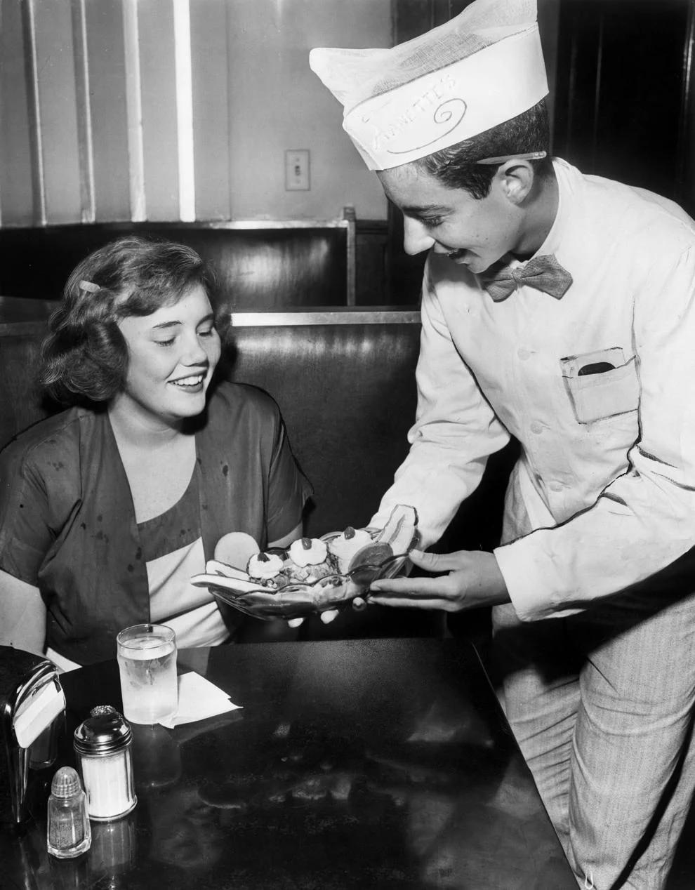 A curb boy at Arnette’s Ice Cream Co., served Beverly Page French a banana split, 1950.