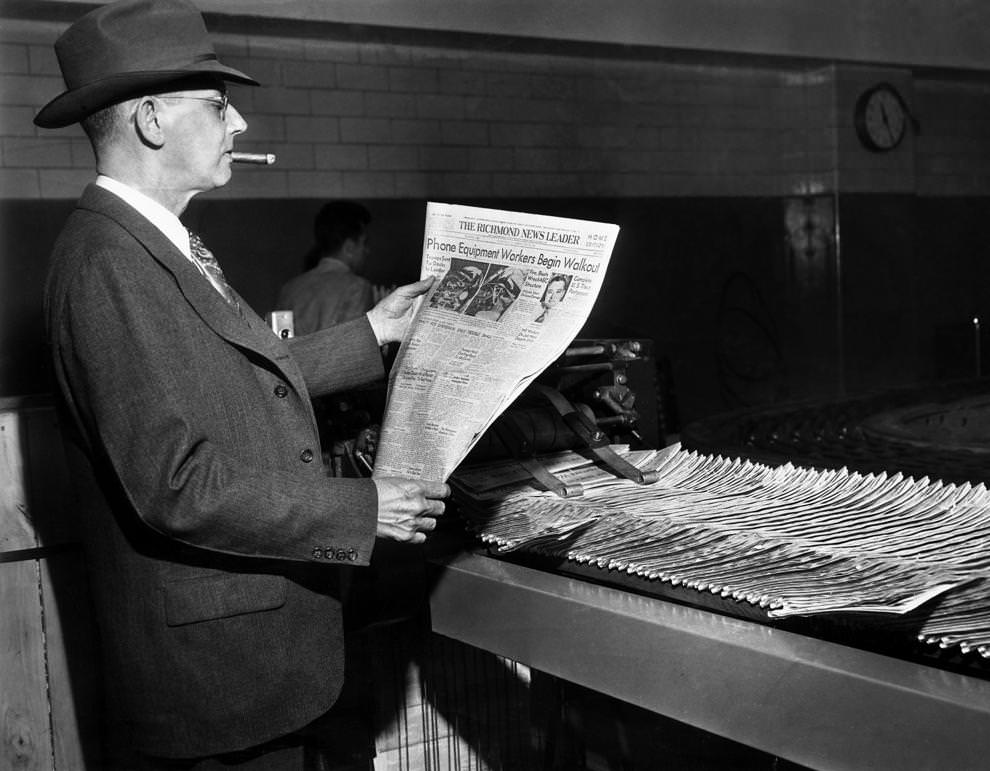 Richmond News Leader city circulation manager E.H. Collins examined one of the first papers to come off the new press, 1950.