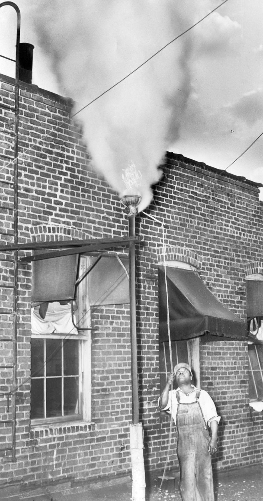 Roman West pulled the cord of a steam whistle at T&E Laundry on Marshall Street in Richmond, 1951.