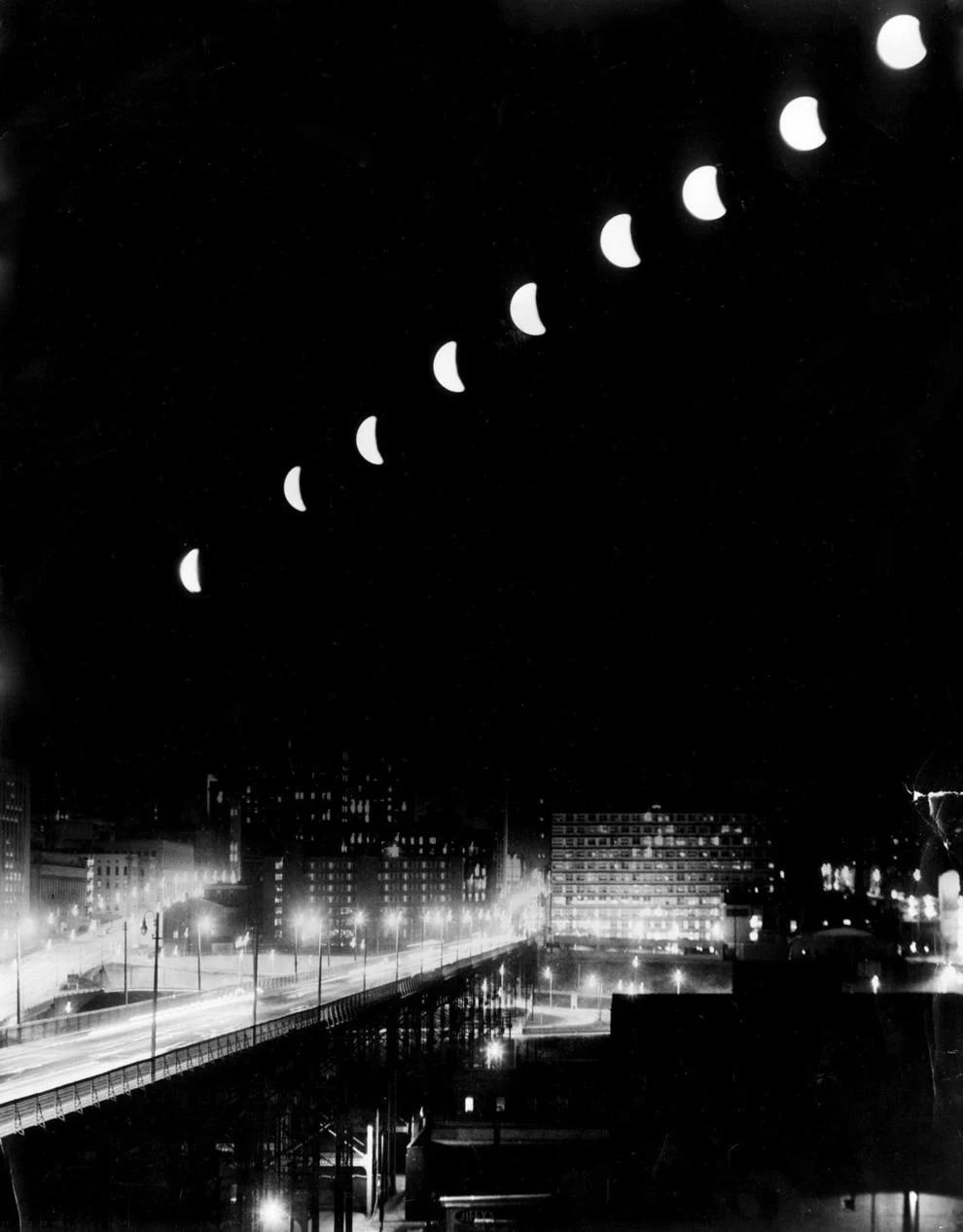 Composite of a lunar eclipse shows a series of images, taken at 10-minute intervals, that were superimposed on a shot of the Richmond skyline, 1963.