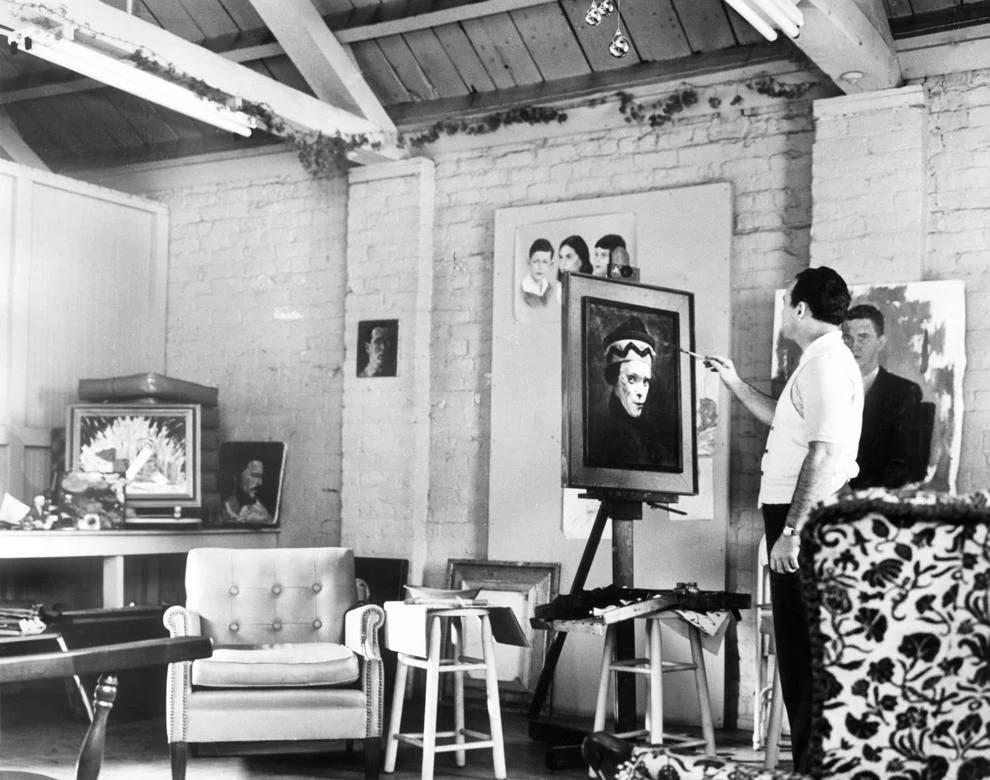 Artist William Kendrick applied the finishing touches to his portrait of a clown, 1961.