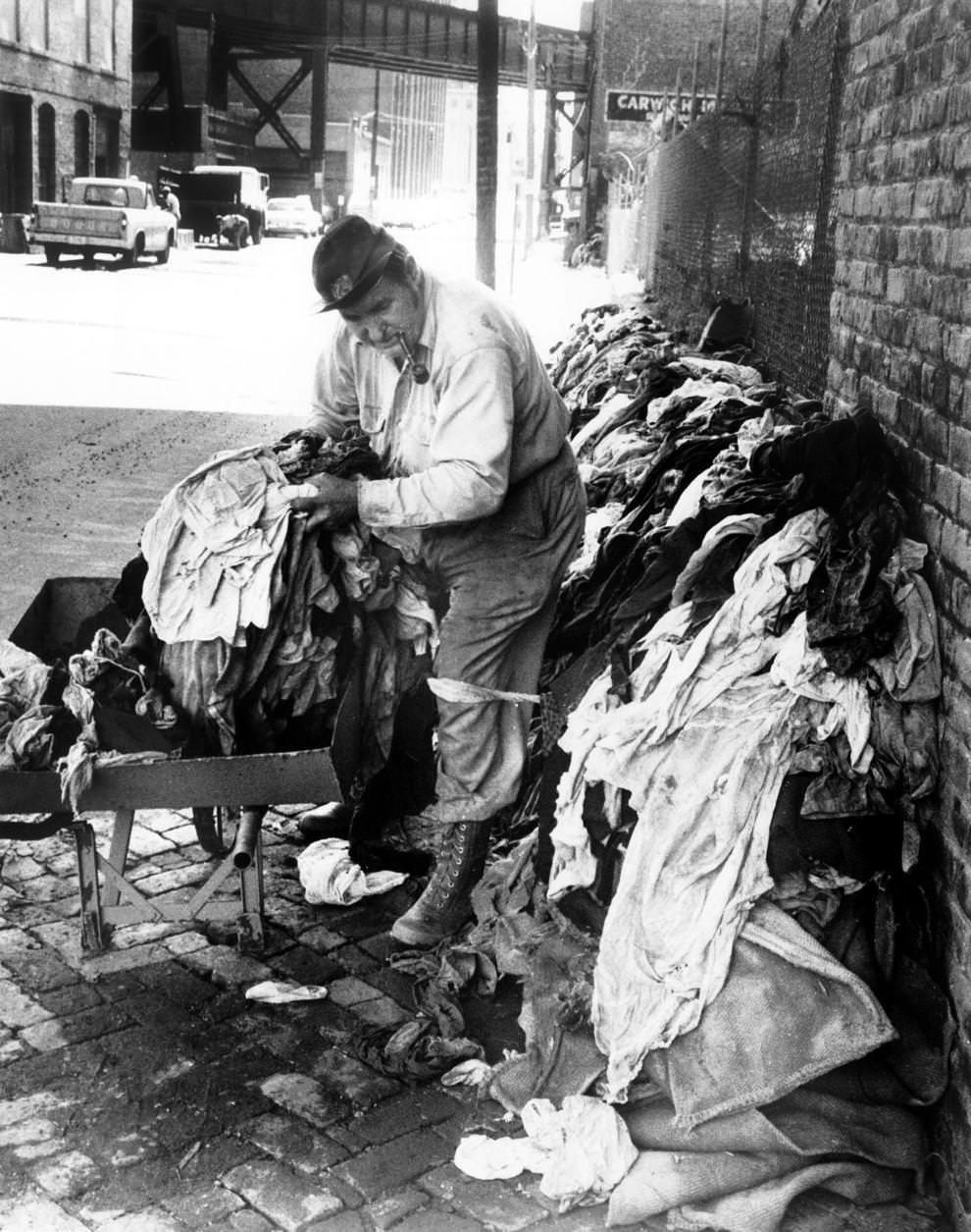 William H. Morse removed damaged clothing from the Clarence Cosby Inc. scrap metal firm on East Cary Street in Richmond, 1962.