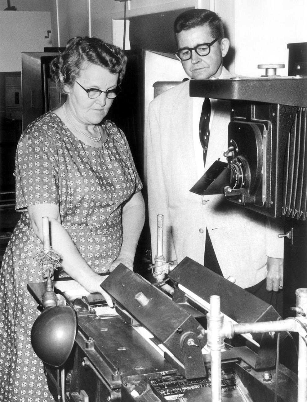 Clara Stitzer photographed driving permit renewal notices under the guidance of DMV official J.B. Warfield in Richmond, 1961.