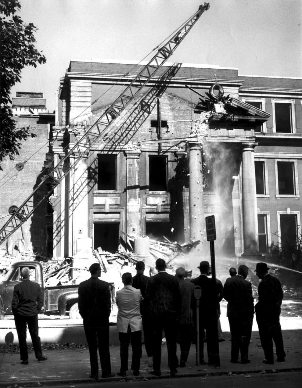 A crane swung a wrecking ball against the portico of the old John Marshall High School in downtown Richmond as a nostalgic crowd watched, 1961.